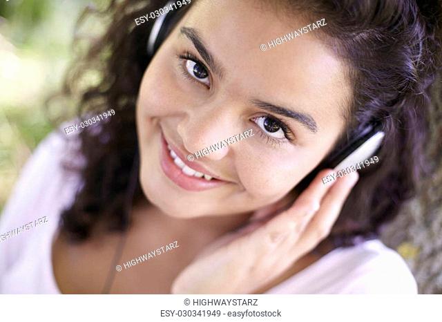 Young Woman Listening To MP3 Player Outdoors