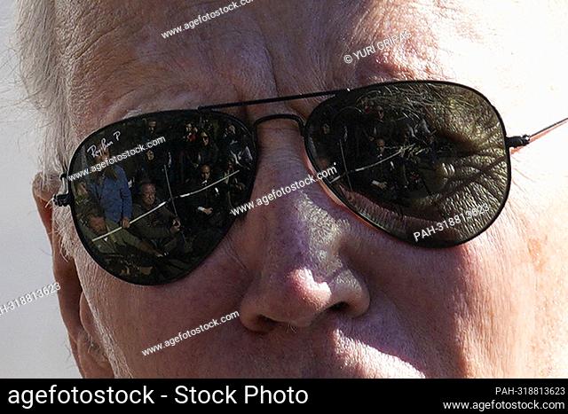 Members of the media are reflected in the sunglasses of United States President Joe Biden as he speaks to the press on the South Lawn of the White House in...