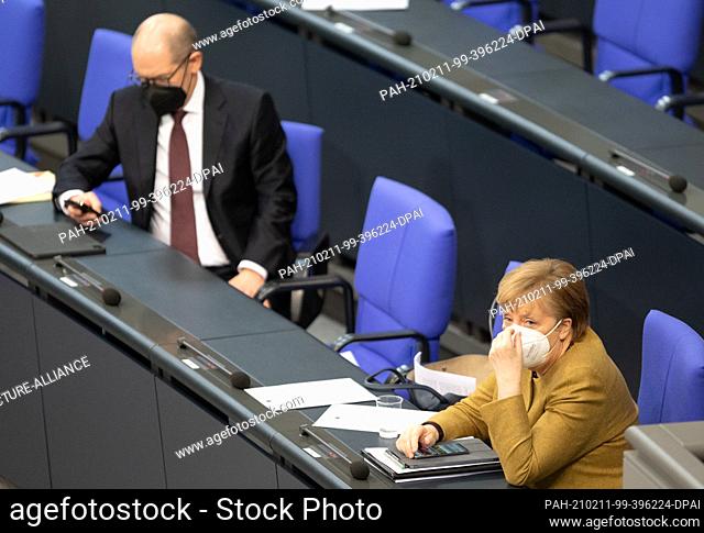 11 February 2021, Berlin: Olaf Scholz (SPD), Federal Minister of Finance, and Chancellor Angela Merkel (CDU) sit on the government bench