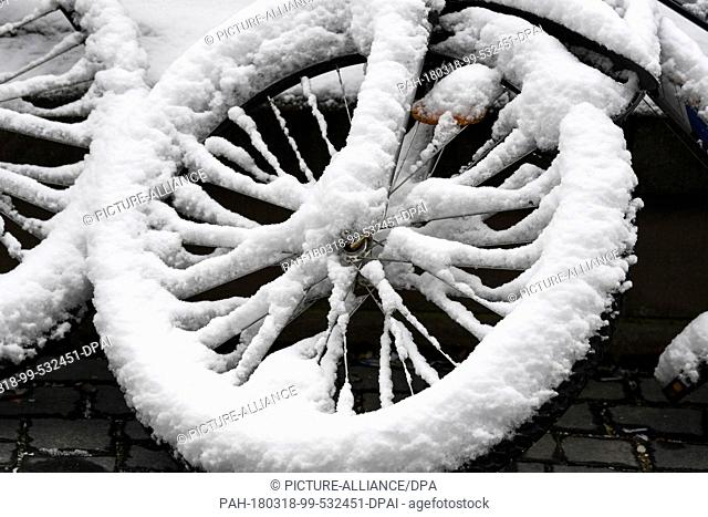 18 March 2018, Germany, Freiburg: A snow-covered bicycle. Photo: Patrick Seeger/dpa. - Freiburg/Baden-Wuerttemberg/Germany