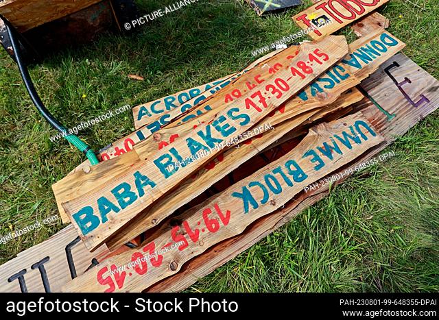 01 August 2023, Saxony-Anhalt, Elend: Signs lie on a festival meadow in Elend . For the festival ""Rocken am Brocken"" , from 3.8. to 5.8