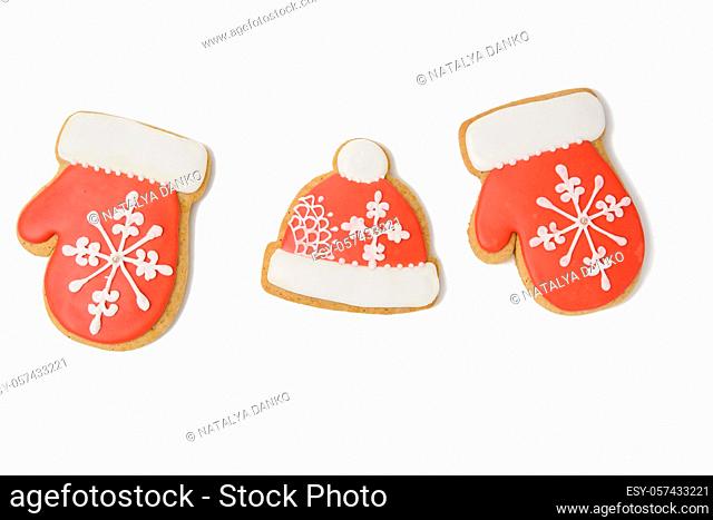 baked gingerbread in the shape of a mitten and covered with red icing, classic Christmas dessert