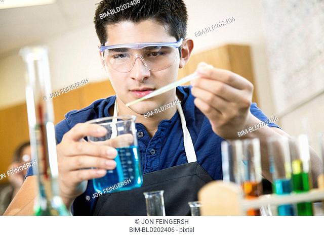 Hispanic student working with chemicals in classroom