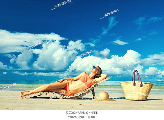 Woman in bikini lying on beach at Seychelles