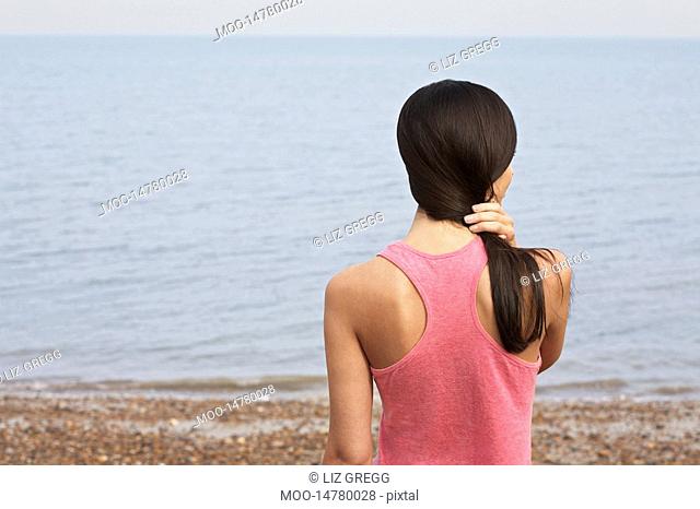 Young woman standing on beach back view