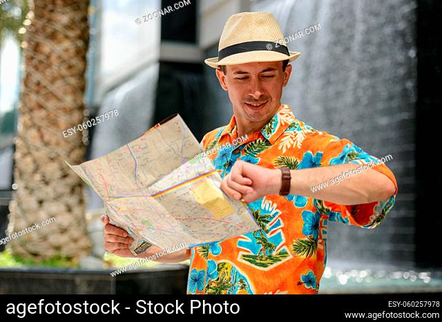 Portrait of young handsome tourist man outside shopping mall in the city