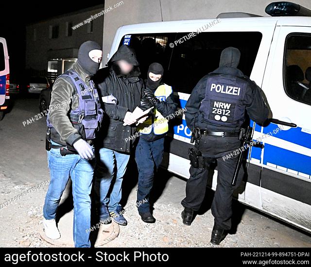 14 December 2022, North Rhine-Westphalia, Solingen: Police officers take away a suspect during a raid in the clan milieu