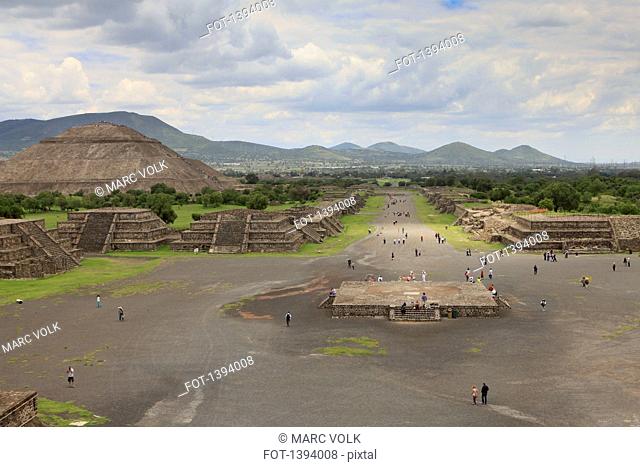 High angle view of people on street by Pyramid of the Sun against cloudy sky