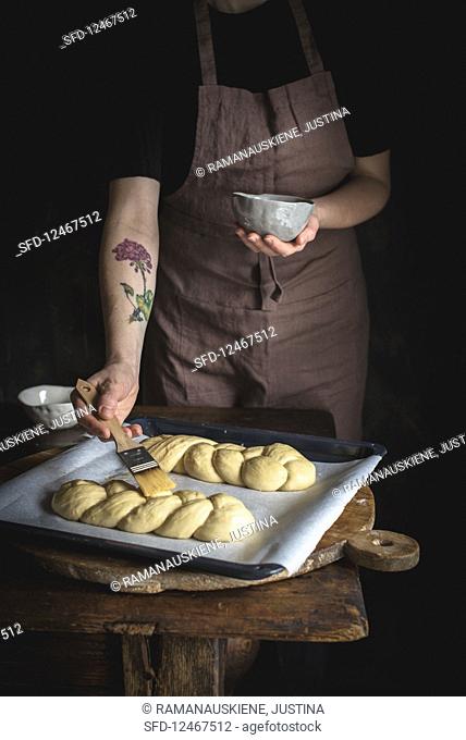 Challah bread (Jewish cuisine) being made: yeast plait being brushed with butter