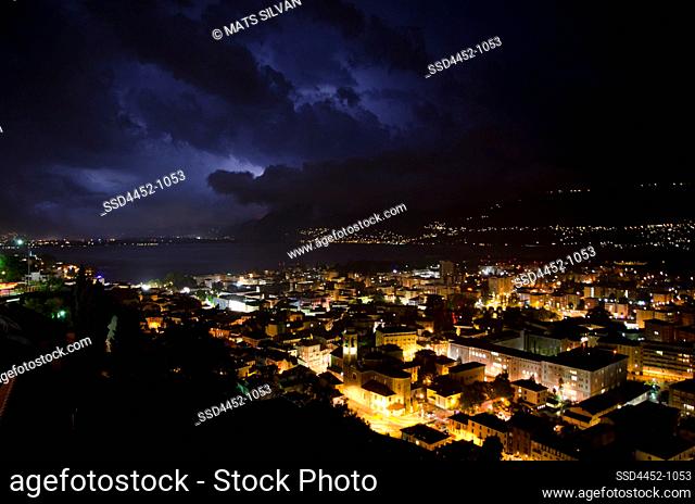 Storm Clouds with Lightning over City of Locarno and Alpine Lake Maggiore with Mountain in Ticino, Switzerland