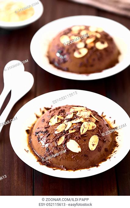 Chocolate pudding or flan with caramel sauce, roasted almond slices and chocolate shavings, photographed with natural light (Selective Focus