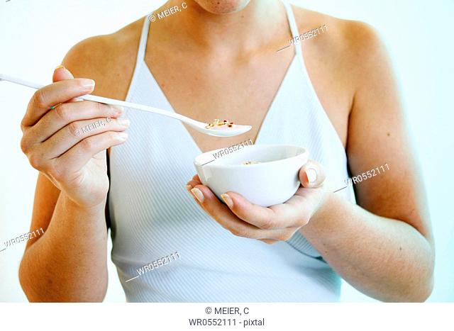 Young woman holds a bowl of cereals