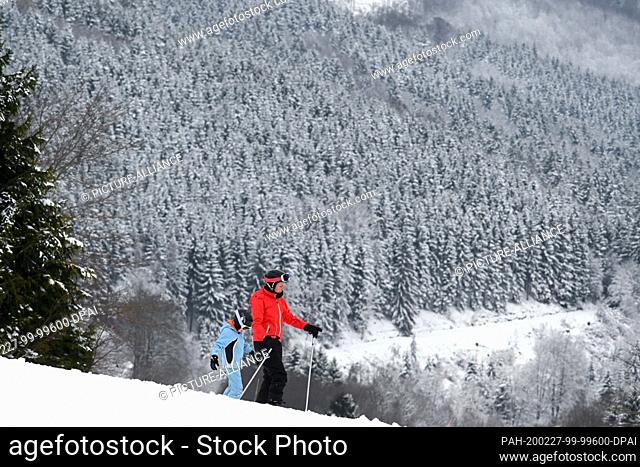 27 February 2020, Hessen, Willingen: A woman is skiing with a child in front of a snowy landscape. More snowfall is expected during the day