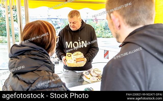 PRODUCTION - 23 July 2023, Hamburg: Axel Pabst sells cheese at the Hamburg fish market. For more than 25 years, Axel Pabst has been working as a market crier...
