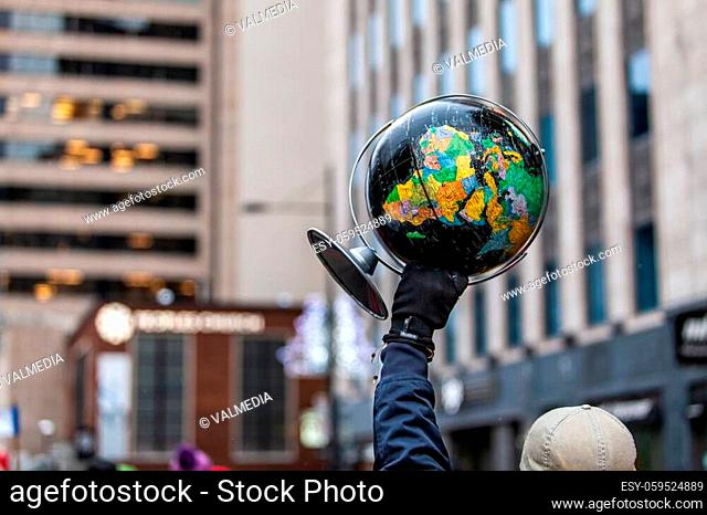 Man is holding a black globe as a sign in an ecological protest