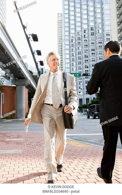 Caucasian businessman walking on city street