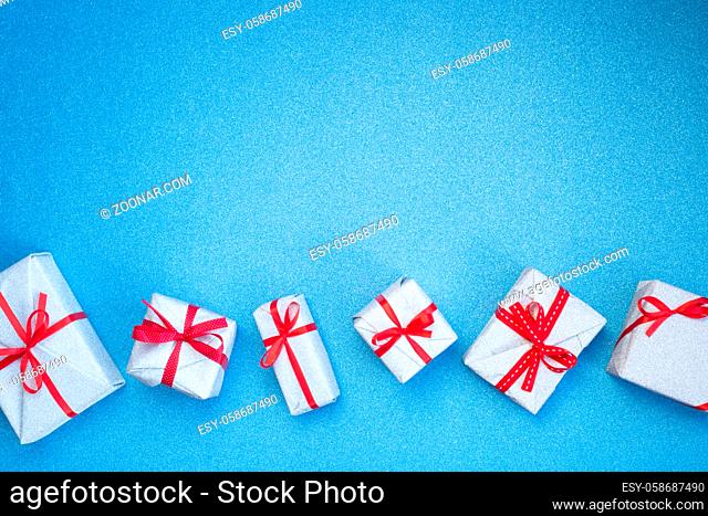 Blue glitter texture christmas background and silver gifts with red ribbon bow , copy space for text , top view flat lay template