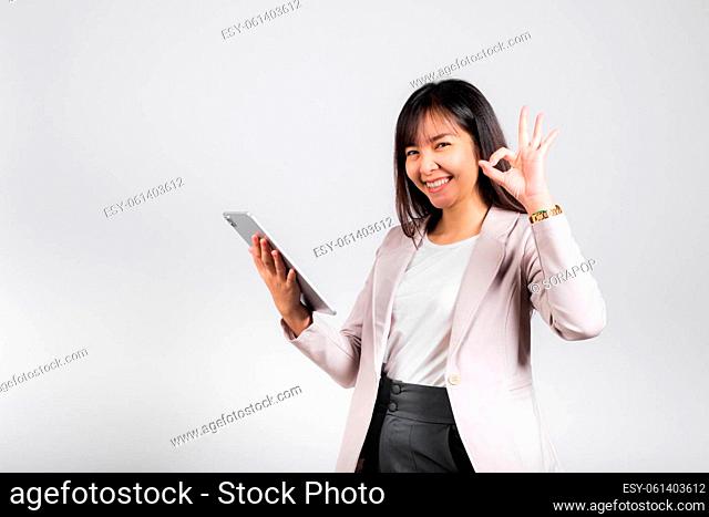 Portrait of Asian beautiful young woman smiling using tablet computer, Happy lifestyle female teen hold digital tablet pc and show OK sign for accept