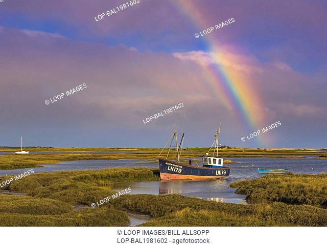 Fishing boat under a rainbow on a stromy day