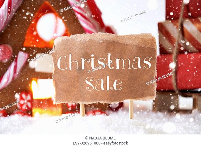 Gingerbread House In Snowy Scenery As Christmas Decoration. Sleigh With Christmas Gifts Or Presents And Snowflakes. Label With English Text Christmas Sale