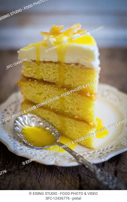 A slice of three-layer lemon cake with frosting