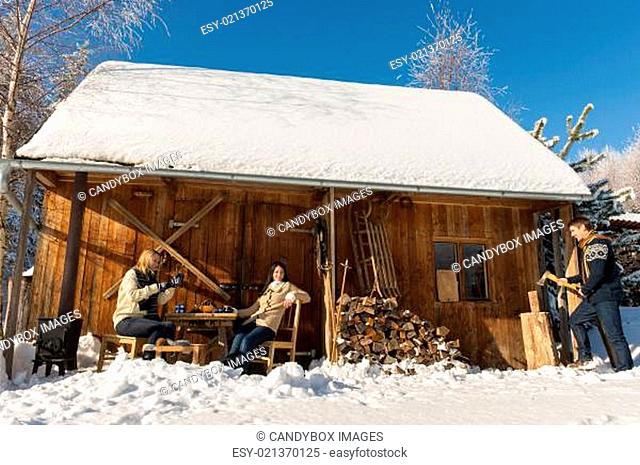 Cozy wooden cottage winter snow people outside