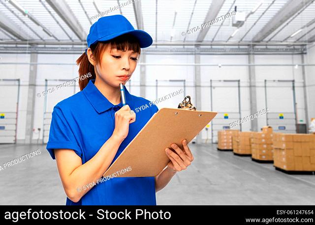 delivery woman with clipboard and pen at warehouse
