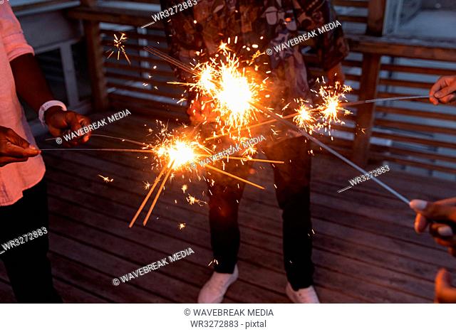 Group of friends enjoying out with sparklers in balcony