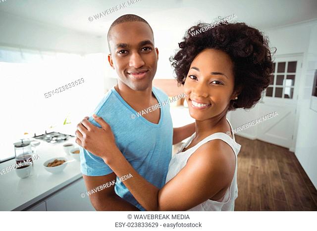 Smiling couple embracing in the kitchen