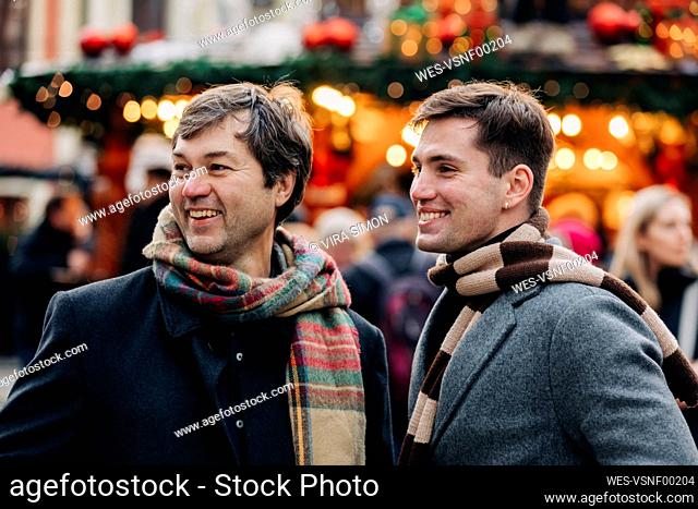 Happy mature man with son at Christmas market