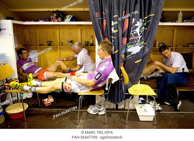 French cyclist Morgen Kneisky (L) is treated by a masseur while his French teammate Vivien Brisse sits on a chair at the 102nd Berlin Six Day Race at Velodrom...