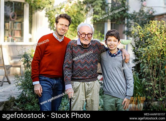 Happy man with father and son in backyard