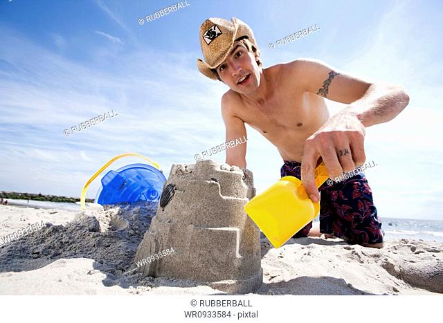 Man building a sand castle at the beach