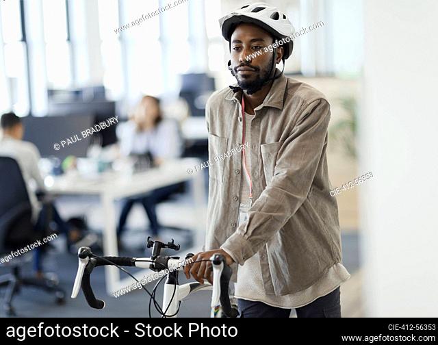 Businessman walking bicycle in office