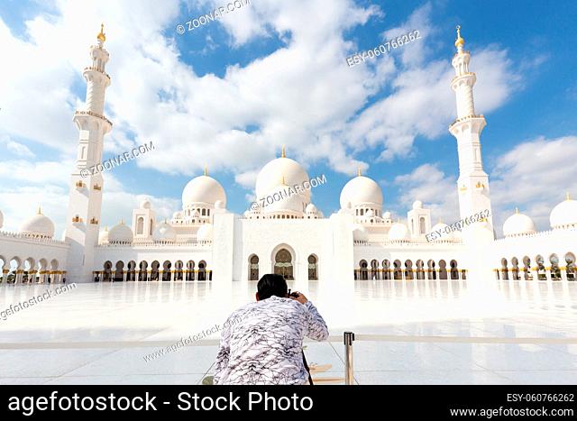 Male tourist taking photo of Sheikh Zayed Grand Mosquem main landmark in Abu Dhabi, the capital city of United Arab Emirates