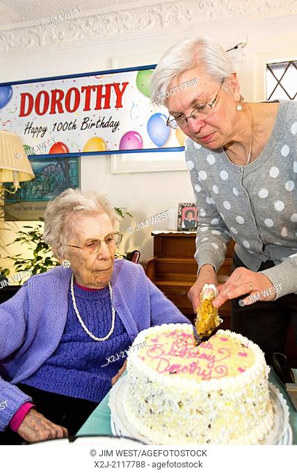 Detroit, Michigan - Woman celebrates her 100th birthday. Her daughter cuts the birthday cake