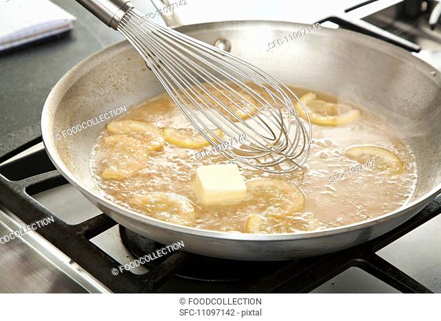 Whisking Butter Into Piccata Sauce in a Skillet