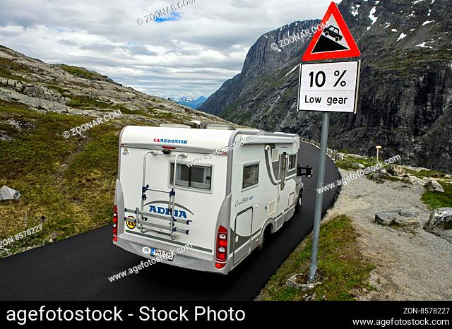 Wohnwagen passiert ein Warnschild vor einer steilen Passage auf der Geiranger - Trollstigen Bergstrasse, Møre og Romsdal, Vestland