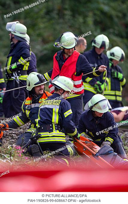 24 August 2019, Saxony, Bad Schandau: Emergency services transport injured people to the ambulances standing on the banks of the Elbe