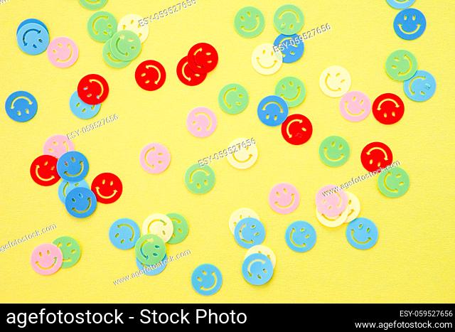 Buntes Smiley Konfetti auf gelbem Hintergrund