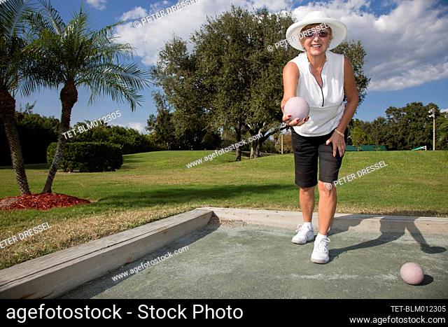 Senior Caucasian woman playing bocce ball