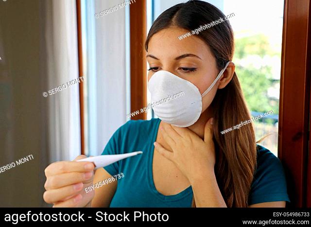 COVID-19 Pandemic Coronavirus Sore Throat Dry Cough Fever Worry Woman Checking Temperature with Thermometer at Home Symptom of SARS-CoV-2