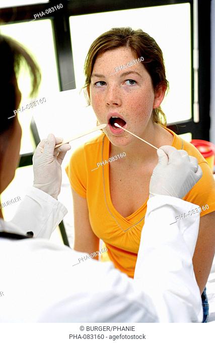 Doctor using a swab to take a sample from her patient's throat