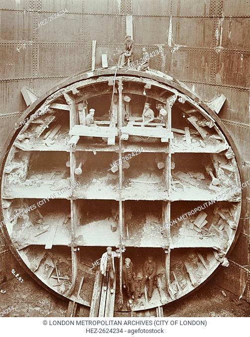 Men standing in the cutting shield, Rotherhithe Tunnel, Stepney, London, August 1907. Front view of the shield with workmen standing in compartments where the...