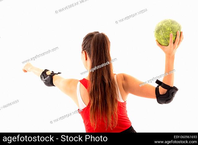 Rear view of caucasian young female player with arm outstretched and handball on white background
