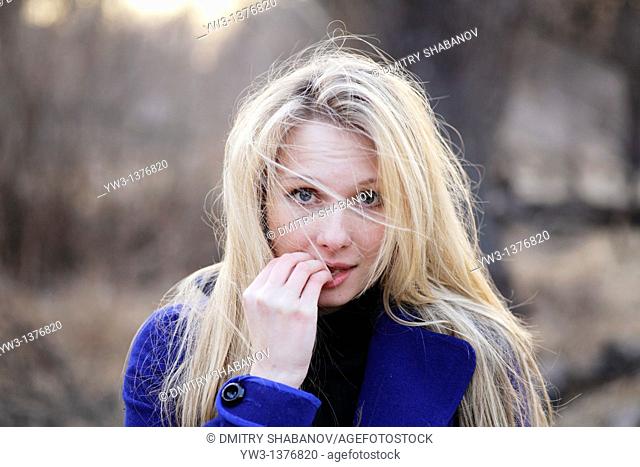 Portrait of beautiful woman in autumn outdoors in blue coat