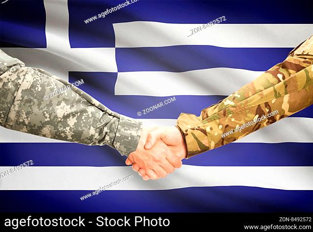 Soldiers shaking hands with flag on background - Greece