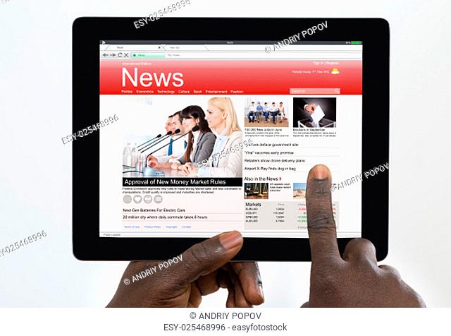 Person Holding Digital Tablet With News On Screen