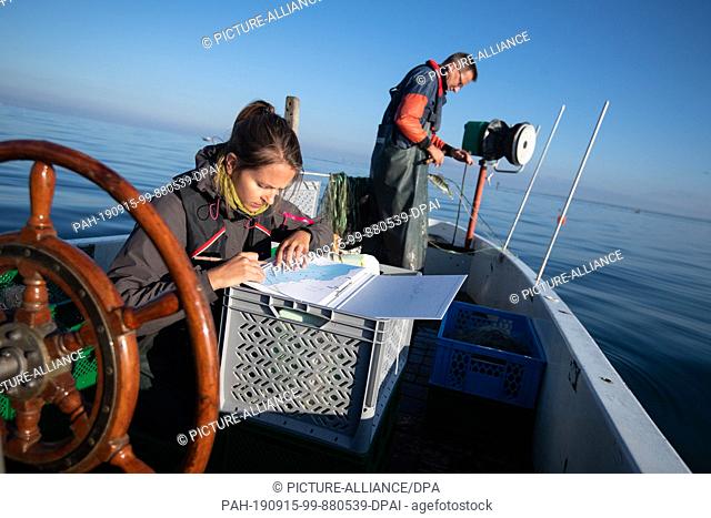 13 September 2019, Baden-Wuerttemberg, Langenargen: Barbara Scholz (l), project manager, notes down data from a catch on a research boat