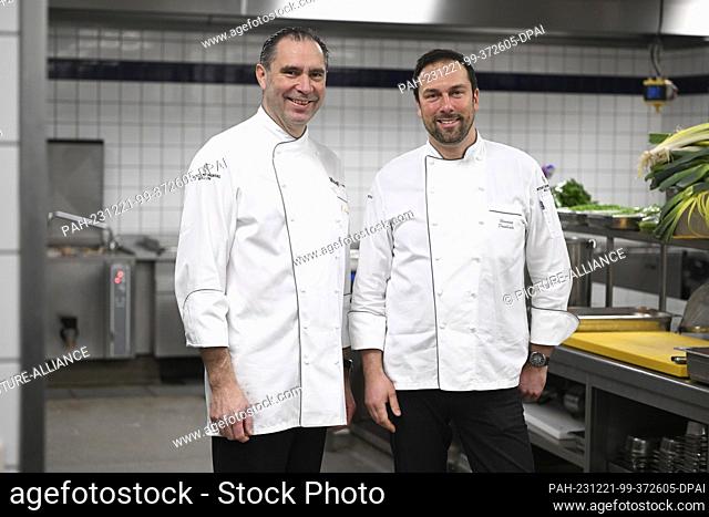 20 December 2023, Berlin: InterContinental head chef Henning Drenkhahn (r) and Michelin-starred chef Eberhard Lange cook for homeless people at the...